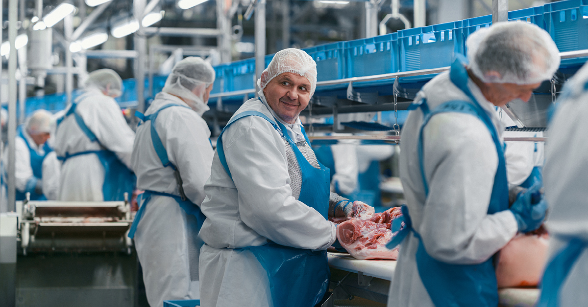 Ein Mitarbeiter steht vor der Kühltheke.