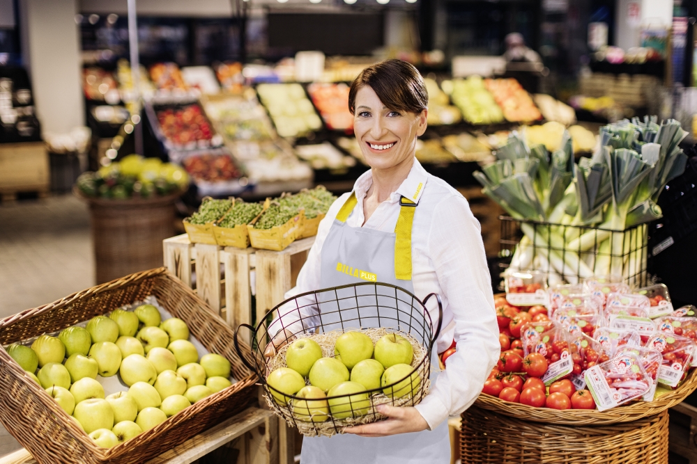 A smiling employee with a fruit basket.