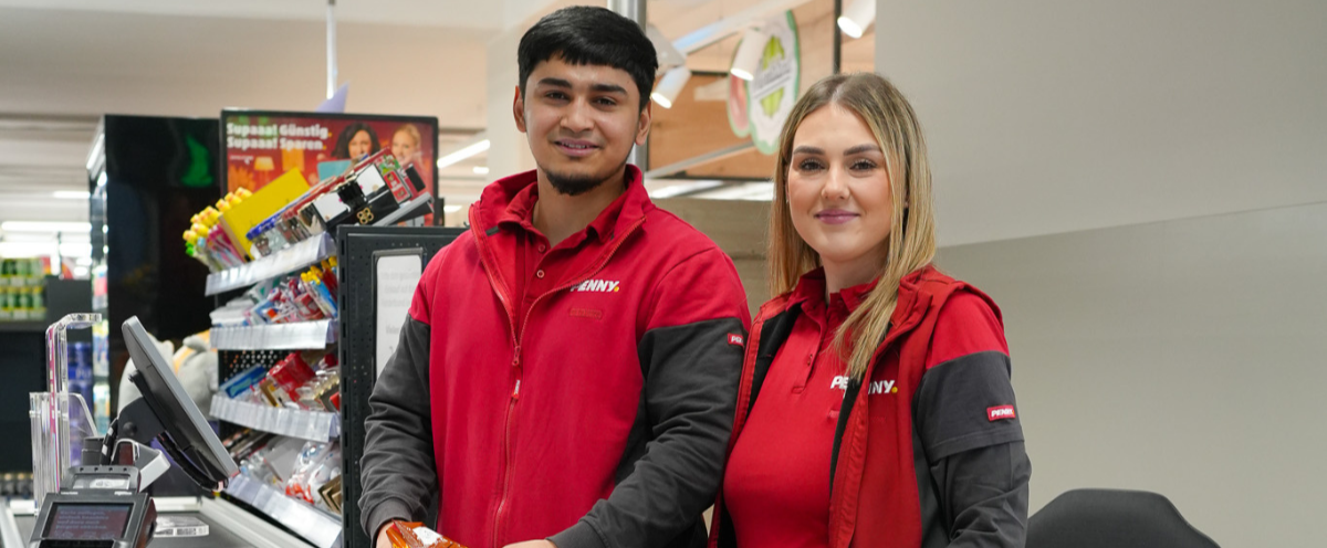 Two employees behind the checkout. 