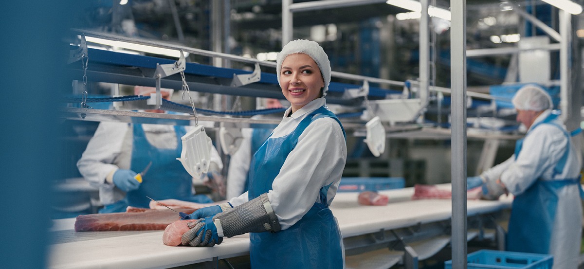 An employee is hanging a piece of meat.